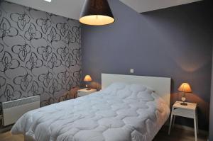 1 cama en un dormitorio con 2 mesas y 2 lámparas en Gite La Grange de Marcel, en Noiseux