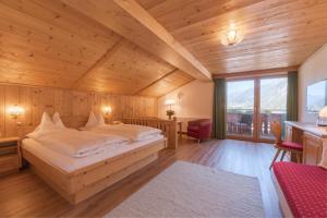 una camera con letto in una stanza con soffitti in legno di Hotel Traube a Pettneu am Arlberg