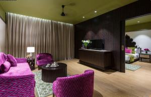 Hotel Lakend في أودايبور: غرفة معيشة مع أثاث أرجواني وسرير