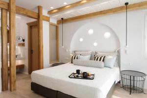 a bedroom with a large bed with a tray on it at Majo Suites Hotel in Agia Anna Naxos