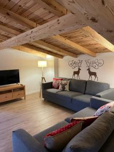 ein Wohnzimmer mit einem Sofa und einem TV in der Unterkunft Chez Tina in Asiago