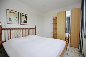 a bedroom with a white bed and a window at Dünenblick Wohnung 44 in Boltenhagen