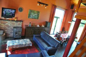 Gite Bouton d'Or في Heure: غرفة معيشة مع أريكة زرقاء ومدفأة