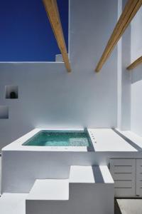 a swimming pool in the middle of a white room at Alleys All-Suite Hotel & Spa in Pirgos