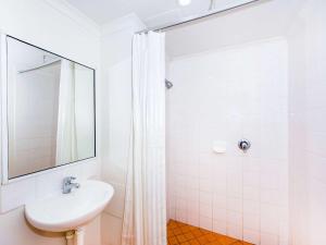 a bathroom with a shower, sink, and toilet at ibis Budget - Dubbo in Dubbo