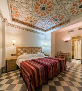 a hotel room with a large bed and a large window at Alcoba del Rey de Sevilla in Seville