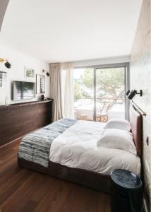 een slaapkamer met een groot bed en een groot raam bij Boutique Hotel Miramar in Monte Carlo