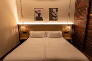 a bed in a room with two pillows at No-Mad Green Hotel in Molinaseca