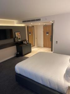 ein Schlafzimmer mit einem großen weißen Bett in einem Zimmer in der Unterkunft Holiday Inn Lincoln, an IHG Hotel in Lincoln