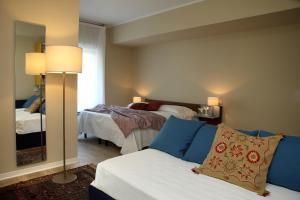 a room with two beds and a couch and a mirror at Hotel Ca' Mura in Bardolino
