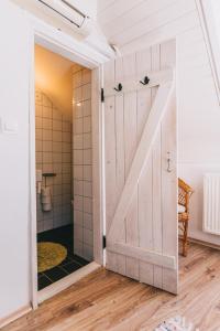 a sliding barn door in a bathroom with a shower at Óbester Panzió in Badacsonytomaj