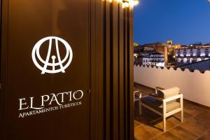 una habitación con un cartel en una ventana con una silla en Apartamentos El Patio Plaza Mayor Cáceres, en Cáceres