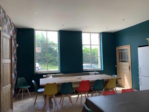 a dining room with a table and colorful chairs at Altegaar in Zottegem
