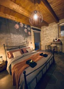 a bedroom with a large bed in a stone wall at B&B Il Fabbro Chambre in Castelmauro