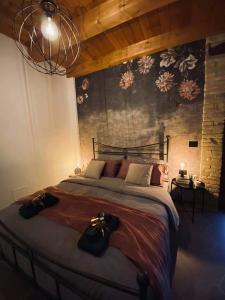 a bedroom with a large bed and a wall with flowers at B&B Il Fabbro Chambre in Castelmauro