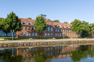 Hotel Hafenresidenz Stralsund في شترالزوند: مبنى بجانب تجمع المياه