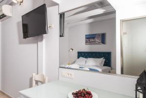 een hotelkamer met een bed en een spiegel bij Denise Beach Hotel in Laganas