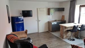 a kitchen with a refrigerator and a table and chairs at Ferienwohnung am Rüstersieler Hof in Wilhelmshaven