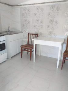 uma cozinha com uma mesa branca e 2 cadeiras em Casa Denisa em Sulina