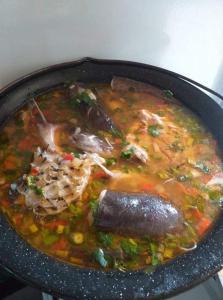 uma panela de sopa com carne e legumes em Casa Denisa em Sulina