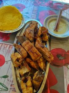 um prato de comida com frango e uma tigela de molho em Casa Denisa em Sulina