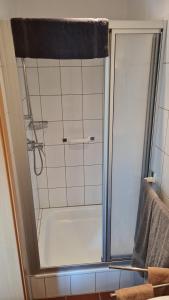 a shower with a glass door in a bathroom at Ferienwohnung am Rüstersieler Hof in Wilhelmshaven +10 photos