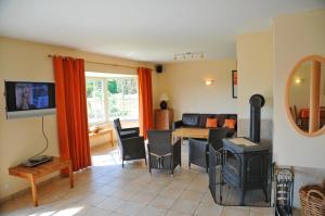 a living room with a table and a stove at Villa Achille in Somme-Leuze