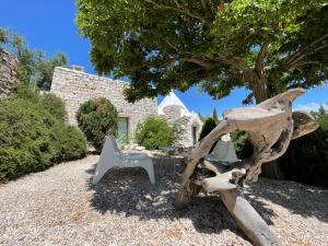 a sculpture of two chairs and a tree at Pietrefitte in Ostuni