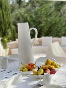 un vaso bianco e un piatto di frutta su un tavolo di Pietrefitte a Ostuni