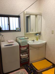 a small bathroom with a sink and a mirror at Youyousanso Traditional B in Tsu