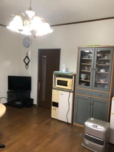 Dieses Zimmer verfügt über eine Küche mit einer Mikrowelle und einem Kühlschrank. in der Unterkunft Youyousanso Traditional B in Tsu
