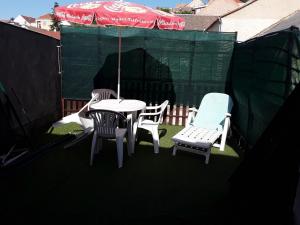 a patio with a table and chairs and an umbrella at Tunnel Family Apartmanház Pécs in Pécs