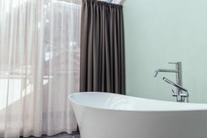 eine weiße Badewanne im Bad mit Fenster in der Unterkunft Tirolerhof in St. Leonhard in Passeier