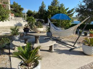 eine Hängematte, ein Tisch, Stühle und ein Sonnenschirm in der Unterkunft Villa Punta in Rovanjska