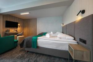 um quarto de hotel com uma cama e uma televisão em Hotel Pod Jedlami em Wisla