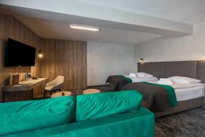 une chambre d'hôtel avec deux lits et un canapé dans l'établissement Hotel Pod Jedlami, à Wisła