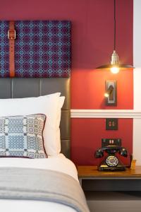 a bed with pillows and a lamp on top of it at Hotel Indigo - Cardiff, an IHG Hotel in Cardiff