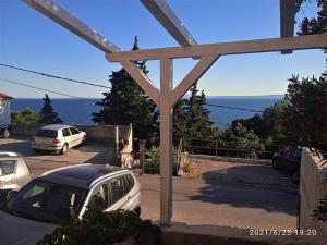 due auto parcheggiate in un parcheggio con vista sull'oceano di Agave apartments a Stara Baška