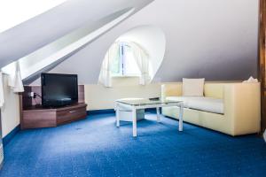 a living room with a couch and a tv at Семеен хотел Анна-Кристина in Vidin