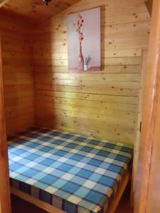 una habitación en una cabaña de madera con una cama en ella en Camping Las Cavenes, en El Cabaco