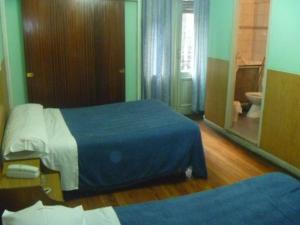 a hotel room with two beds and a mirror at Hotel San Martin in Buenos Aires