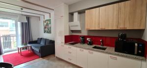 a kitchen with white cabinets and a couch in a room at Apartamenty EverySky - Źródlana 2 in Świeradów-Zdrój +1 photo
