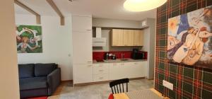 a living room with a couch and a kitchen at Apartamenty EverySky - Źródlana 2 in Świeradów-Zdrój