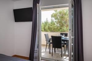 Pokój ze stołem i krzesłami oraz przesuwnymi szklanymi drzwiami w obiekcie la More Apartments w mieście Borovići