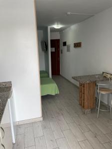 a room with a kitchen with a table and a green couch at Koka Beach in Playa del Ingles