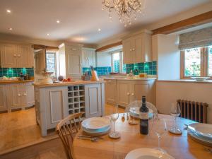 a kitchen with a wooden table with wine glasses at May Blossom Barn in Newton Abbot