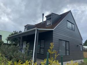 a black house with a window on top of it at Hirangi cottage in Turangi