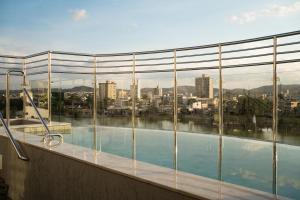 ein Schwimmbad mit Blick auf eine Stadt in der Unterkunft Hotel Atlas in Sete Lagoas