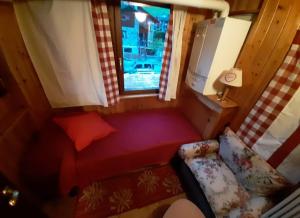 um pequeno quarto com um sofá e uma janela em Casa Chiara em Nus