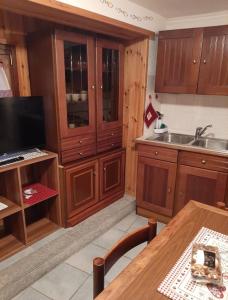a kitchen with wooden cabinets and a wooden table at Casa Chiara in Nus